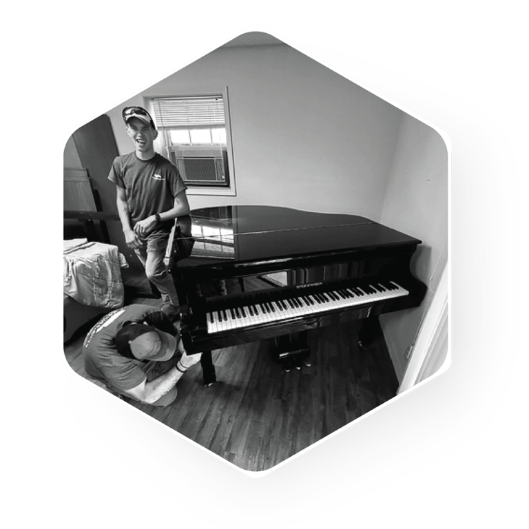 The Moving Guys team moving a piano