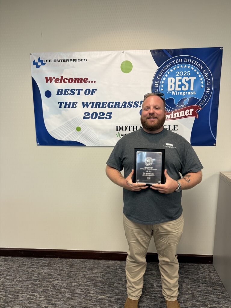 Man proudly holding a plaque in front of a “Best of the Wiregrass 2025” banner.
